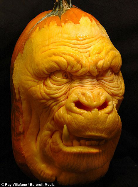 A gorilla face carved out of a pumpkin using spoons and scalpels 